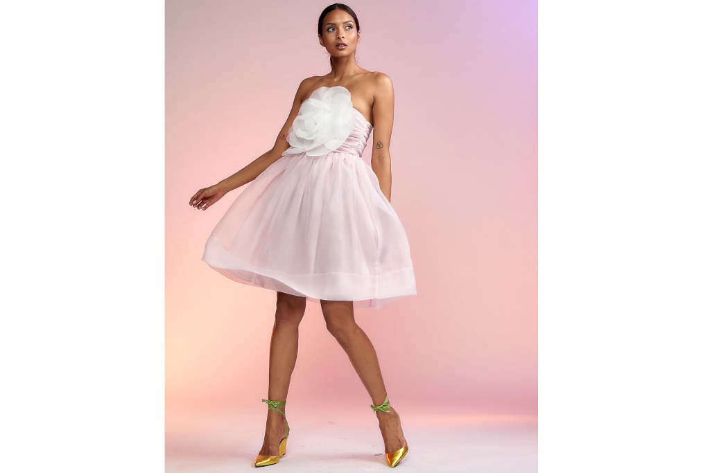 Woman in short pink dress with large with corsage on front