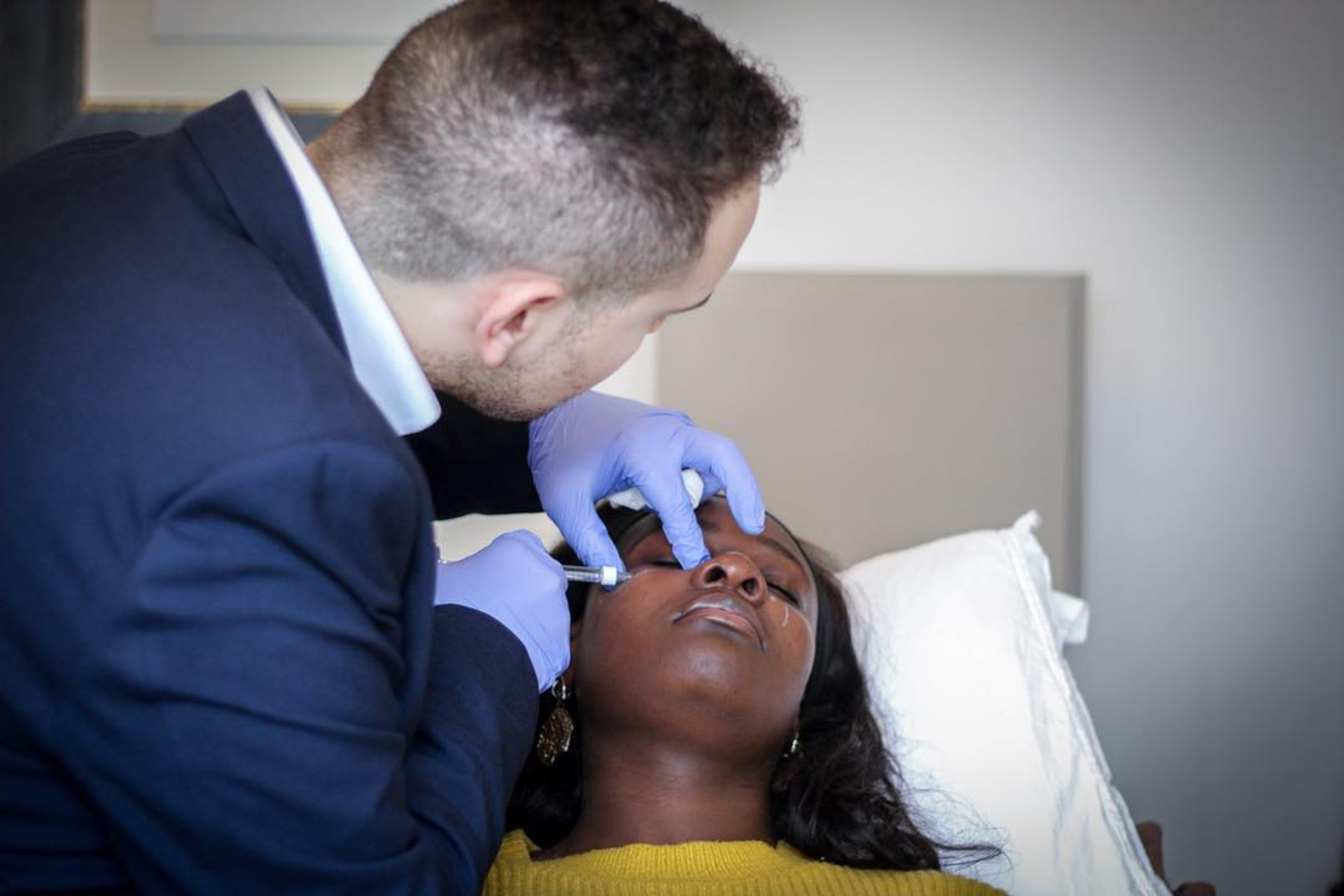 Man performing aesthetic treatment on woman