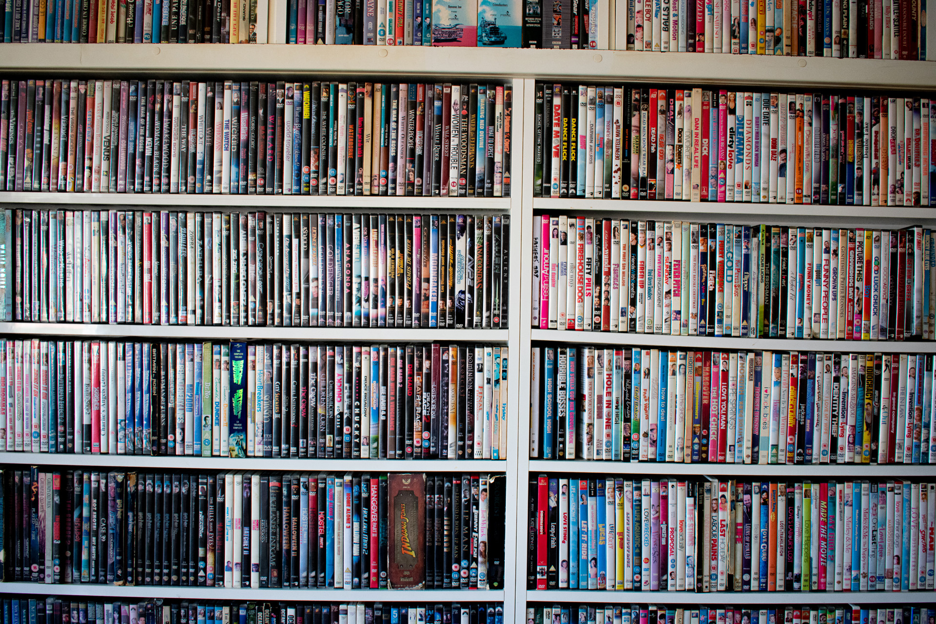 Movies in DVD cases on a shelf used as decoration for a pub