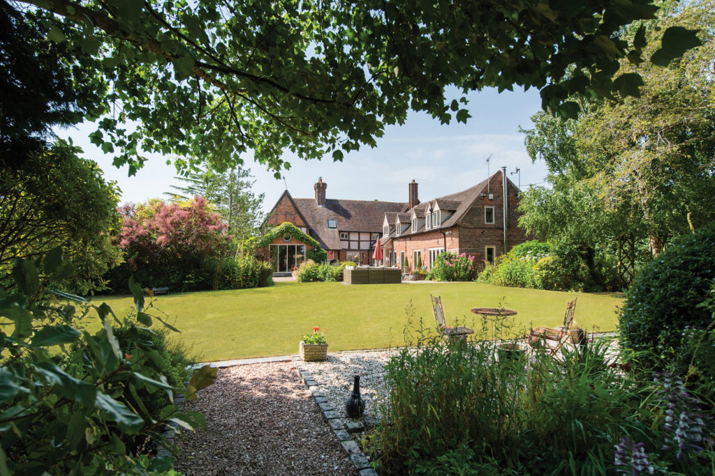 Red brick country manor with lawns and a terrace area.