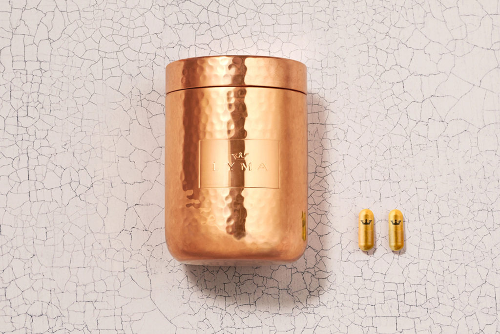 Rose gold tin with two pills on cracked background