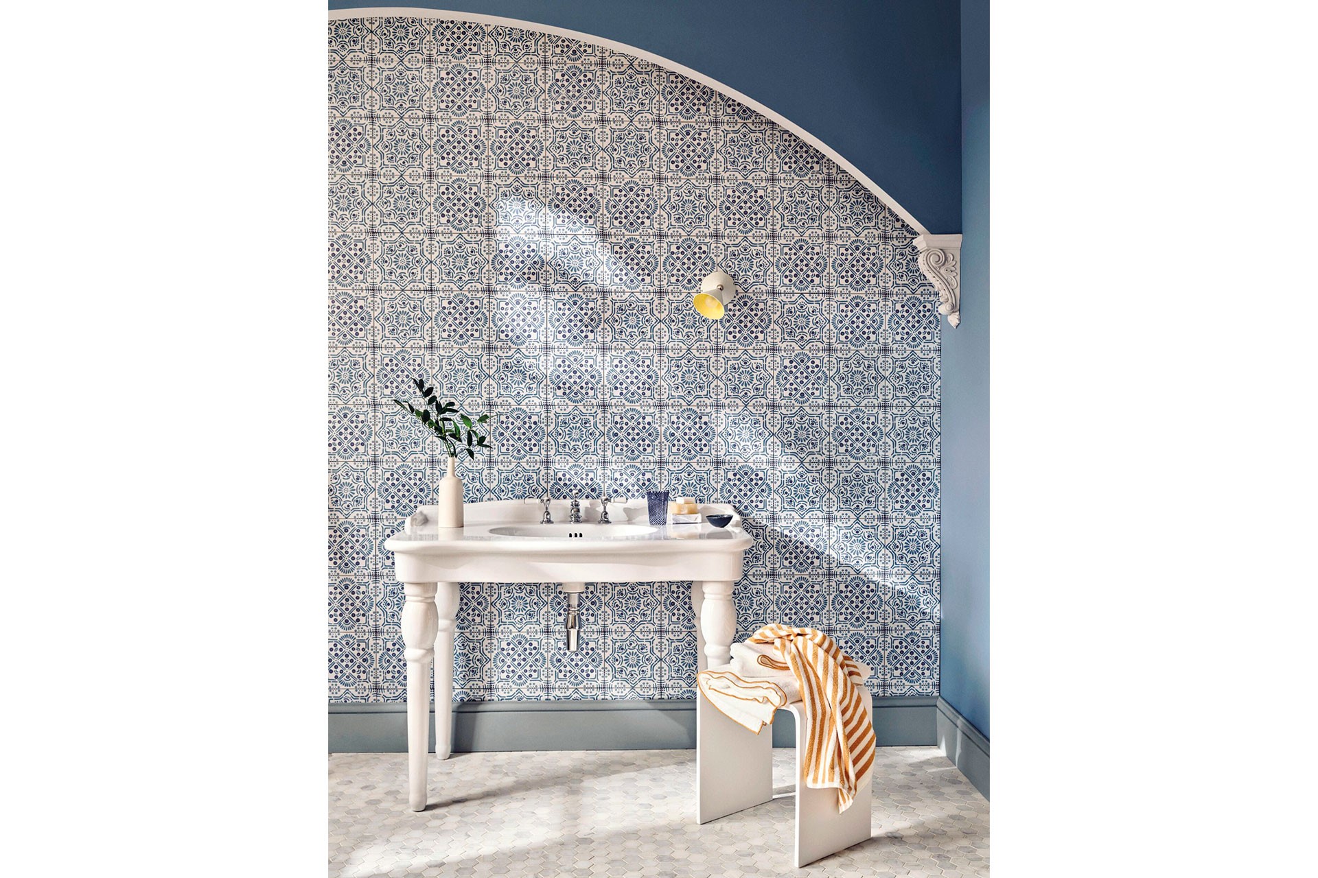 A sink beside blue patterned wallpaper