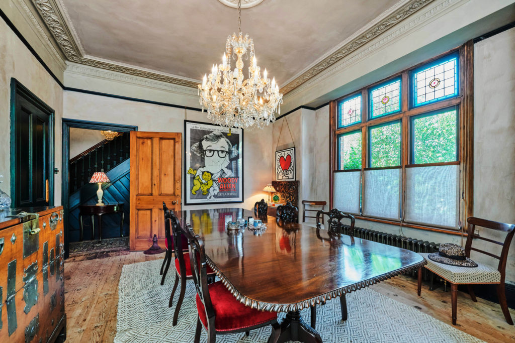 Dining room with mahogany table, chandelier and ceiling cornicing.