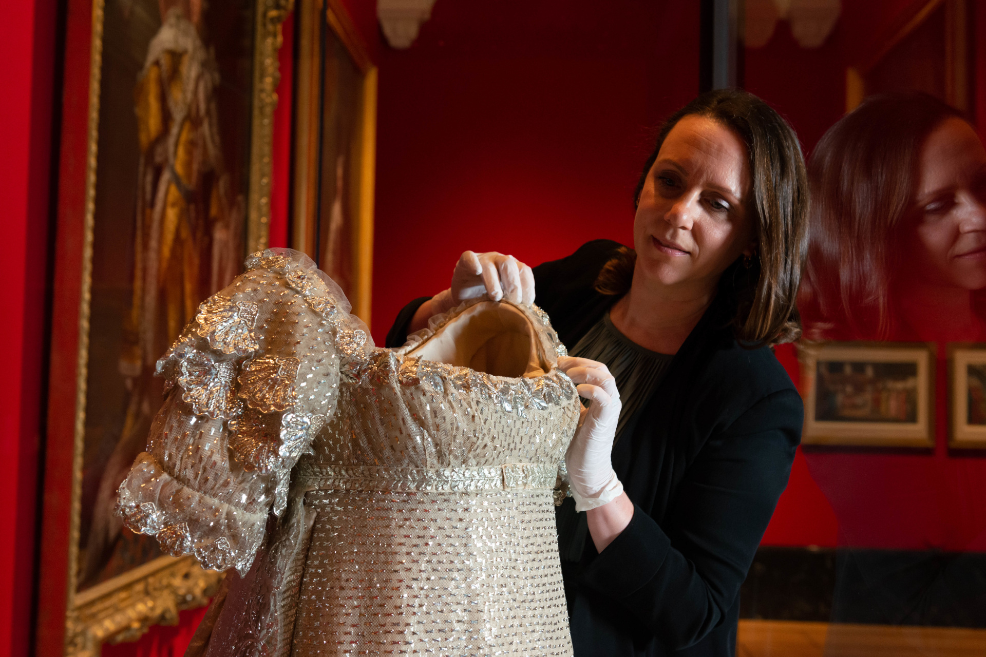 Woman adjusting Georgian dress display