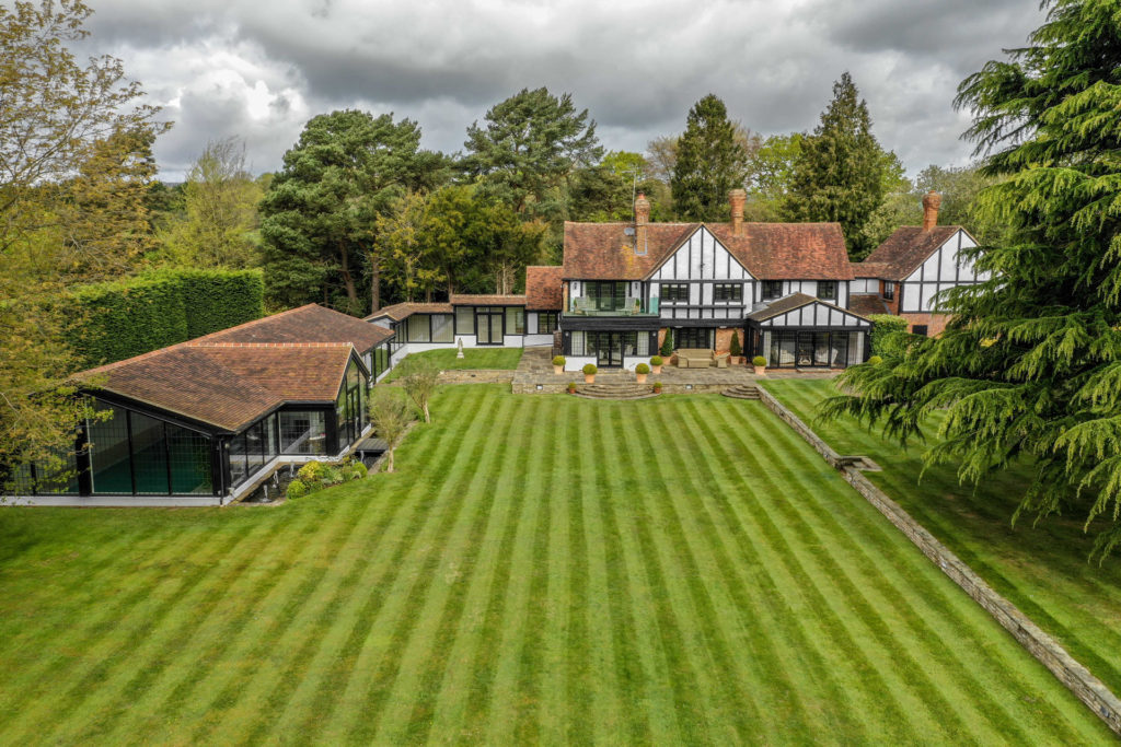 Tudor-style estate with landscaped lawns and outbuildings.