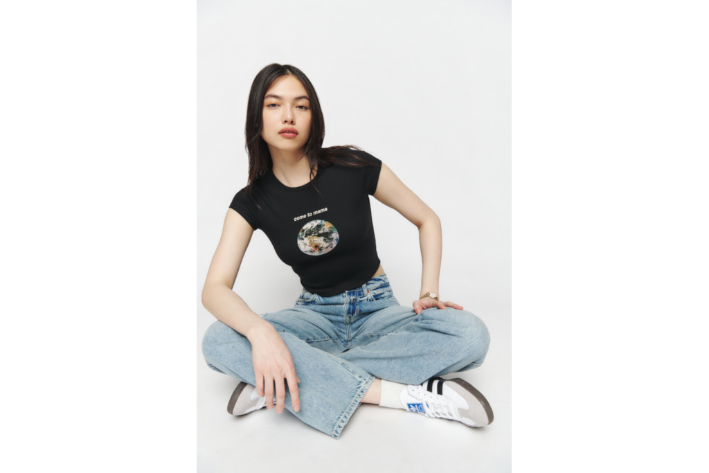 Woman sat cross-legged in black tee and jeans