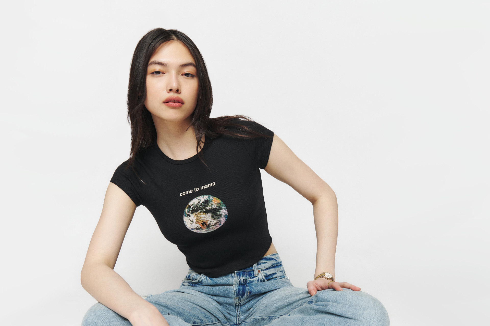 Woman sat cross-legged in black tee and jeans