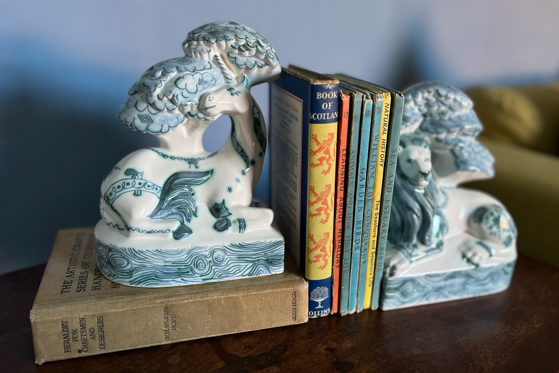 Intricately decorated blue and white bookends with old books in between.
