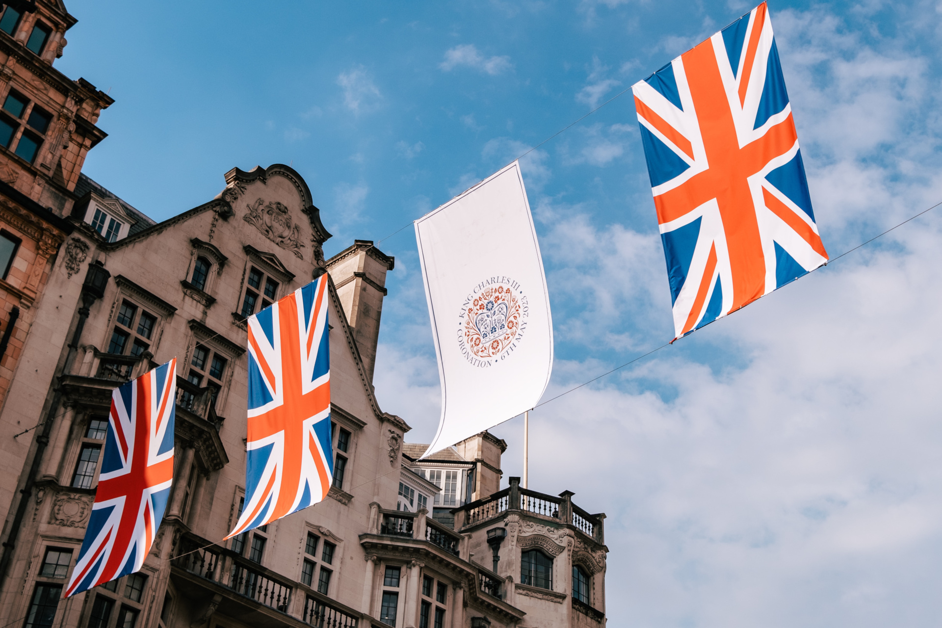 Union Jack and coronation emblem bunting on blue sky - brands the royals love