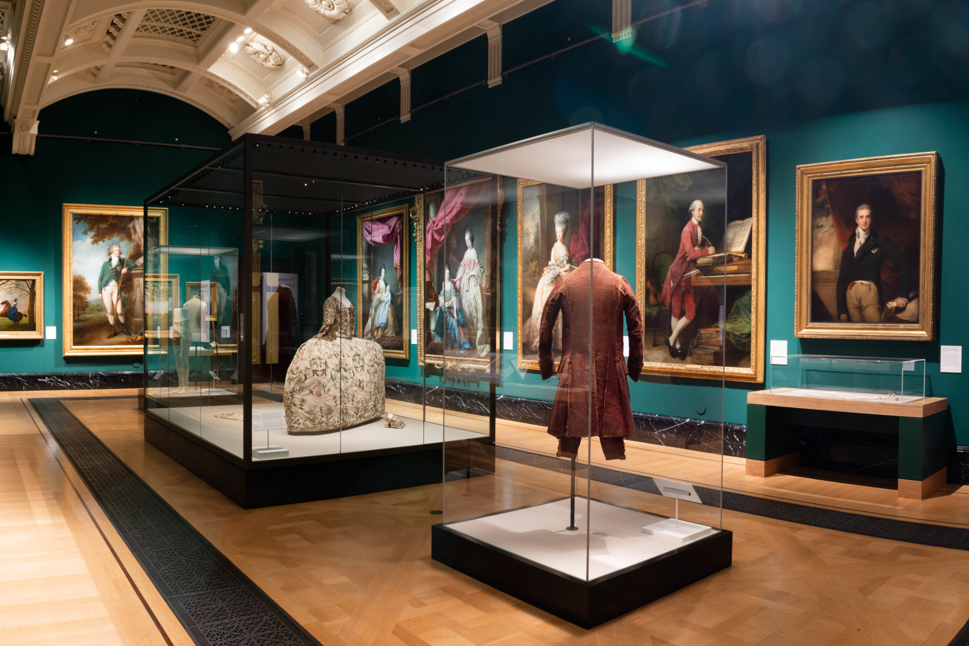 Style & Society: Dressing The Georgians exhibition room with paintings and clothing in display cases