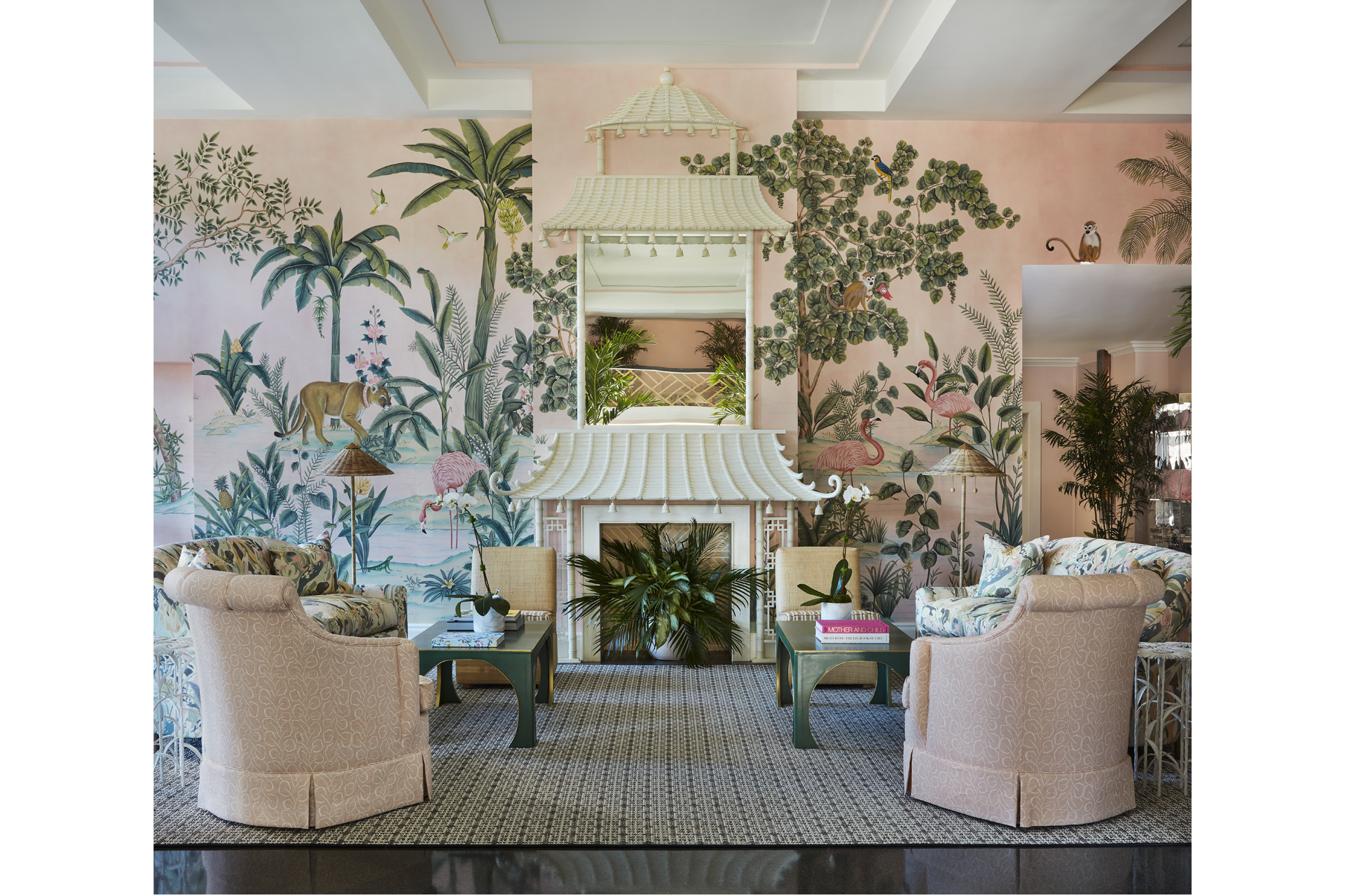 A sitting room with pink walls and a tree mural