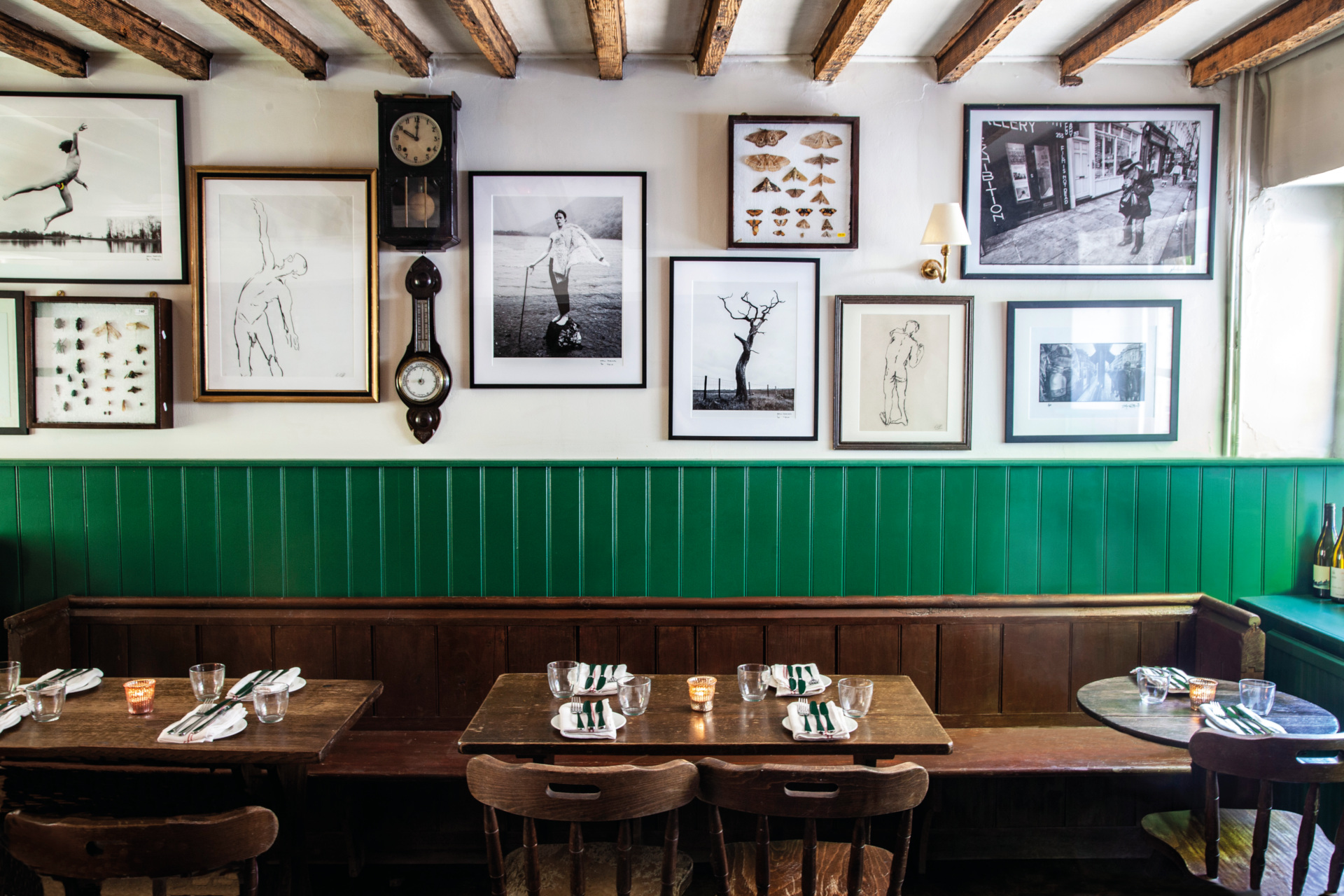 Dining room with green wooden panel walls and framed pictures