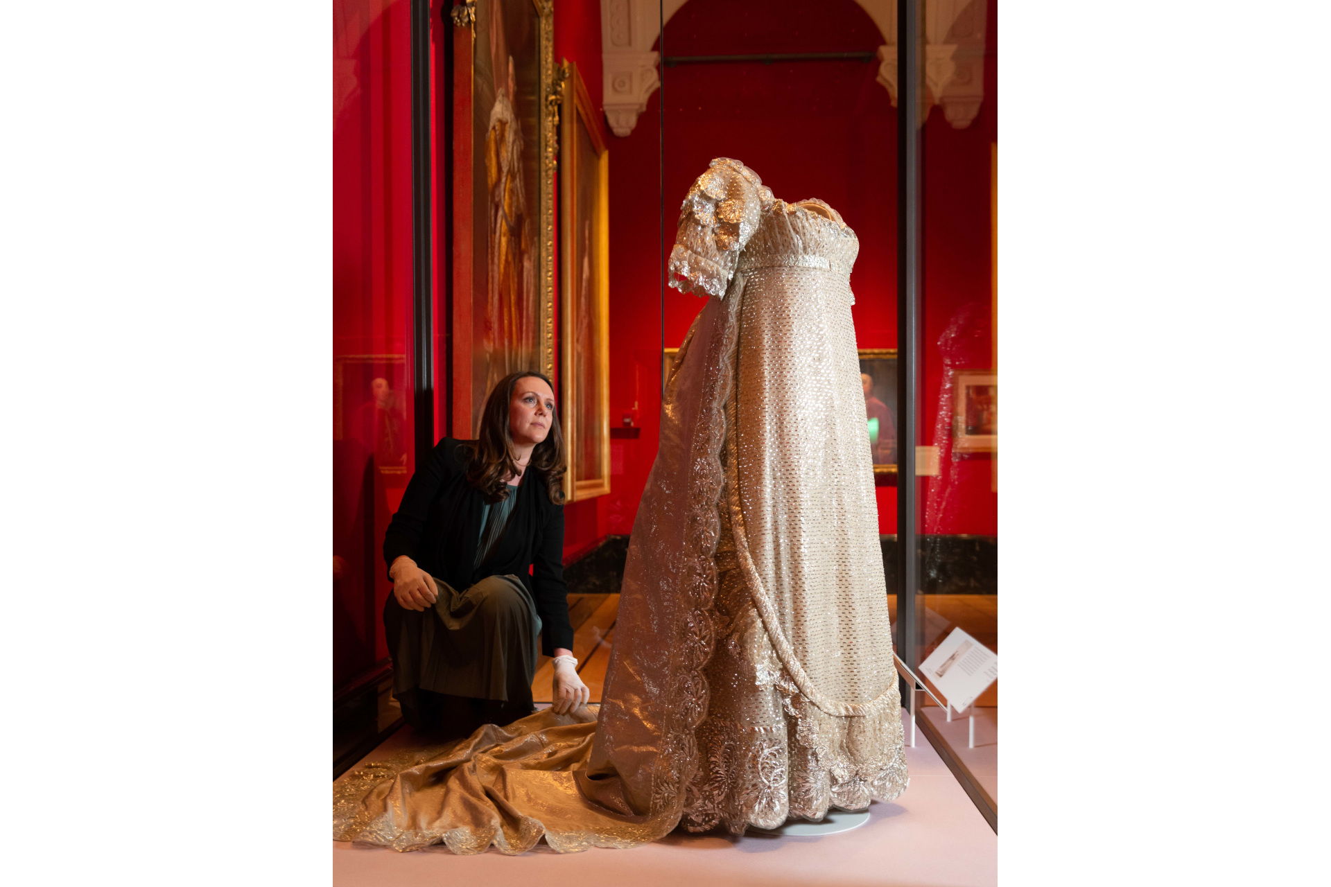 Woman adjusting Georgian dress display