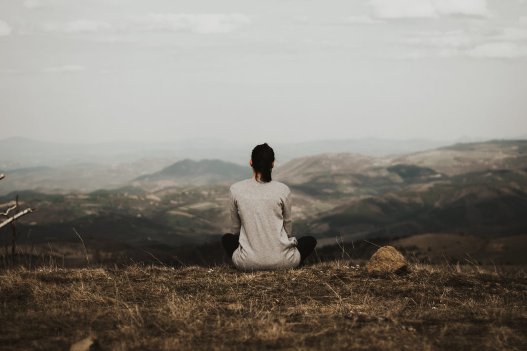 Woman sat looking over countryside hills