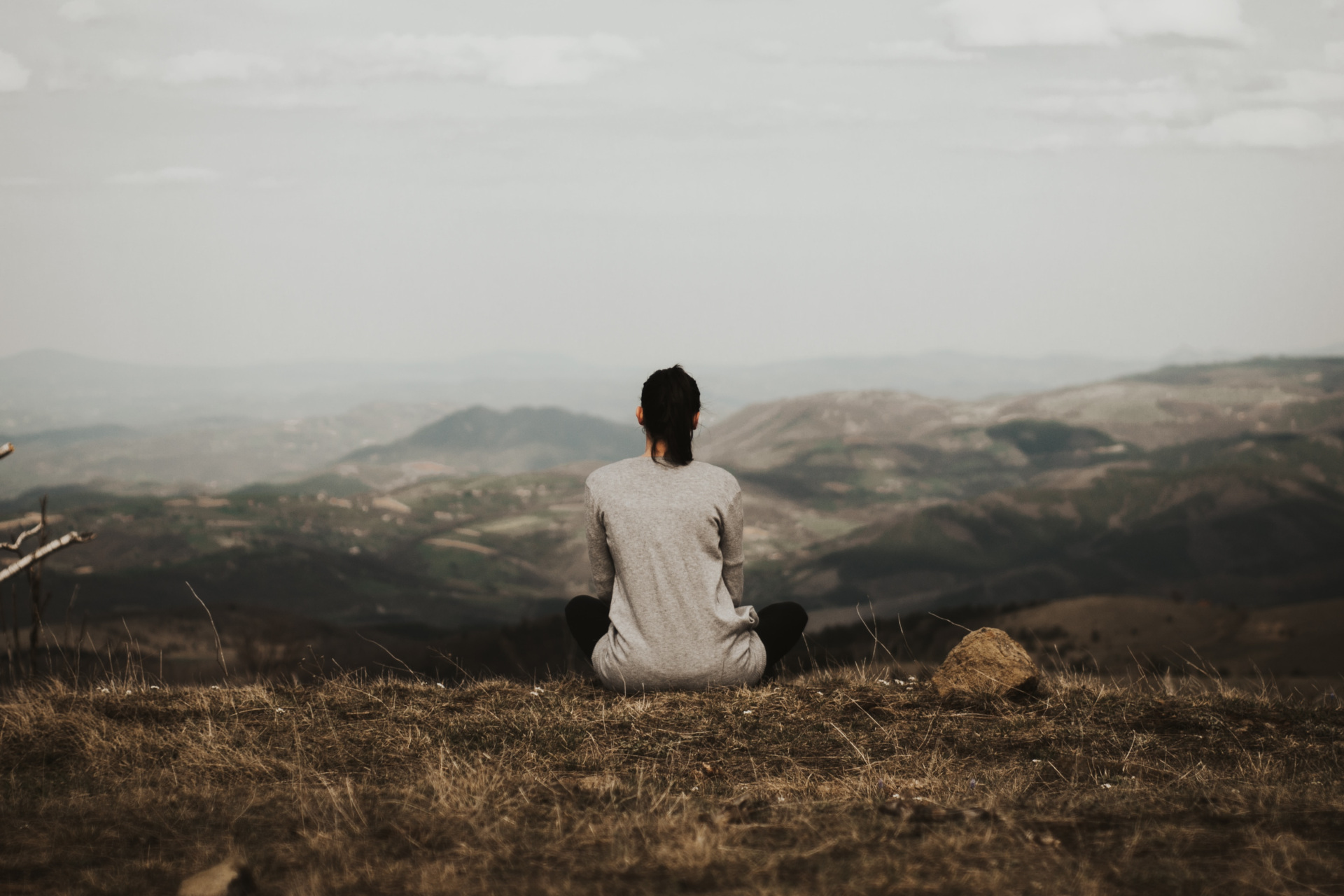 Woman sat looking over countryside hills