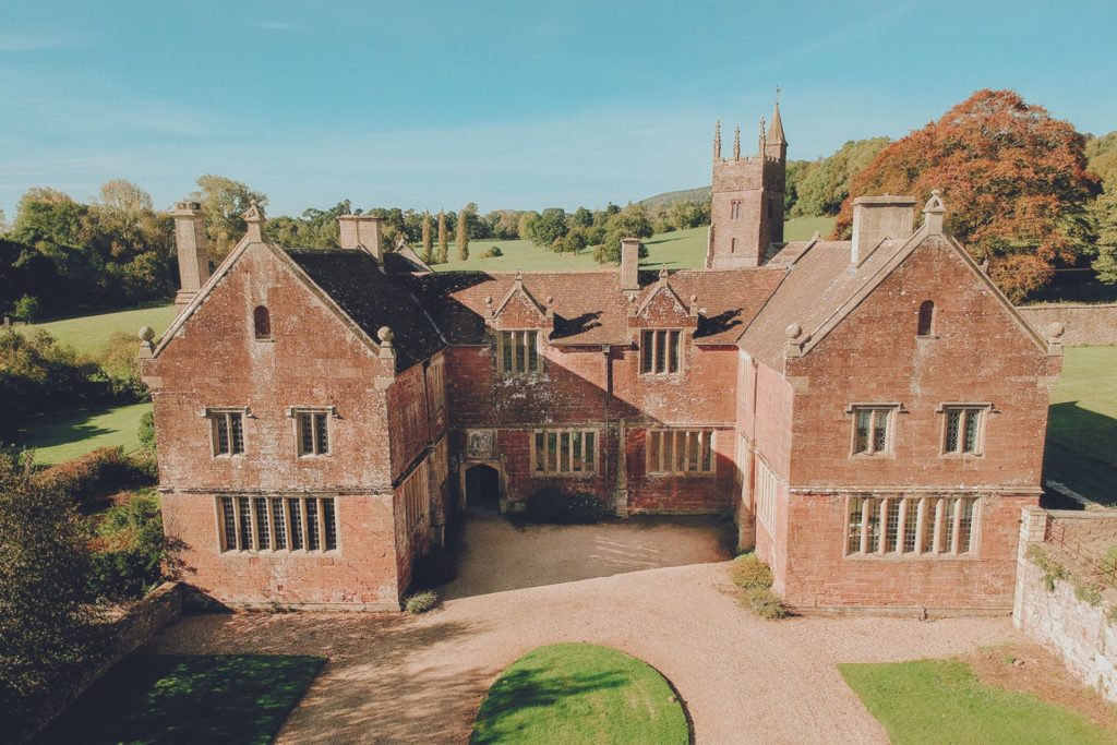 Aerial view of large red brick manor.