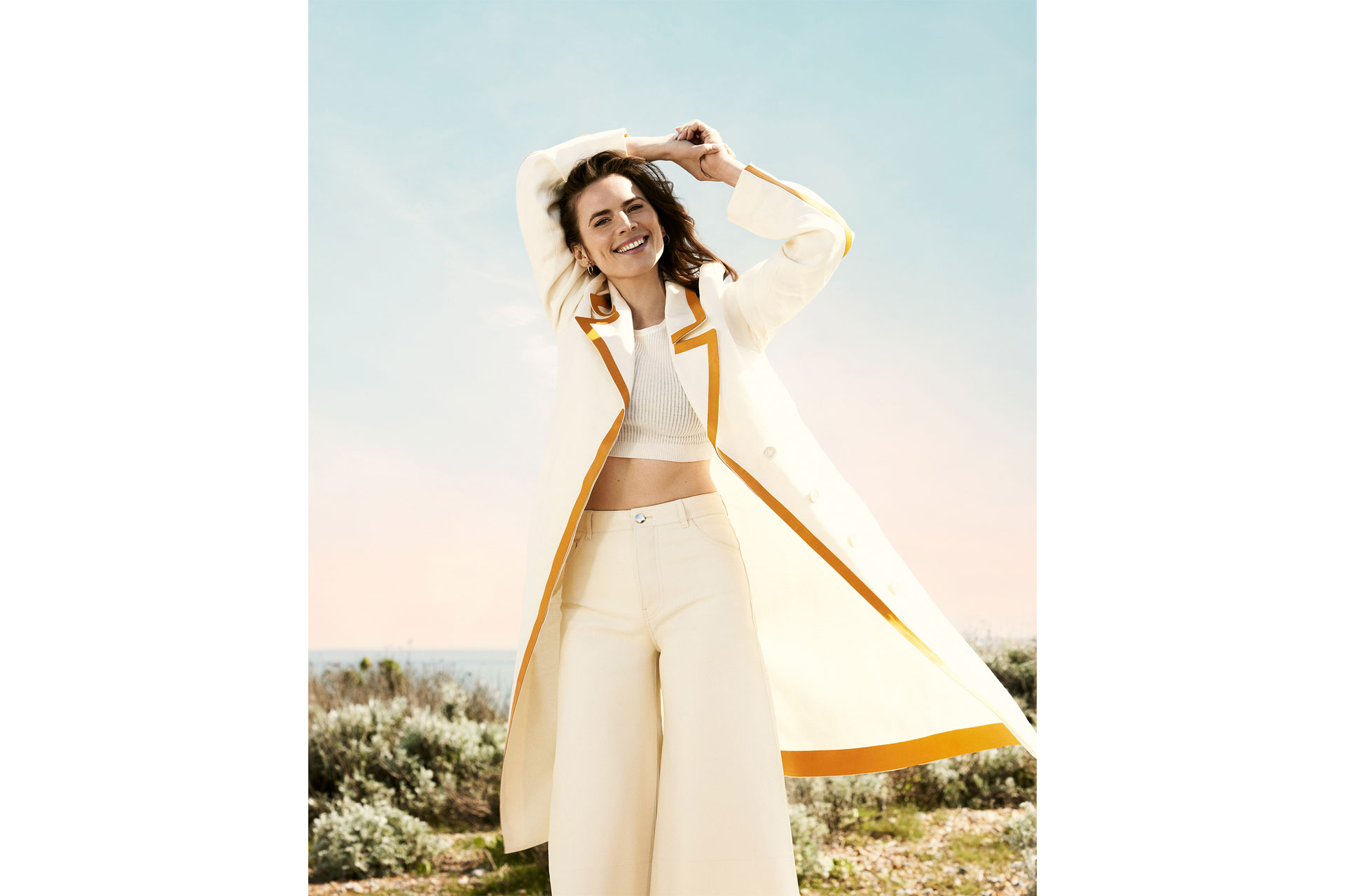 Hayley Atwell looks happy wearing long white coat