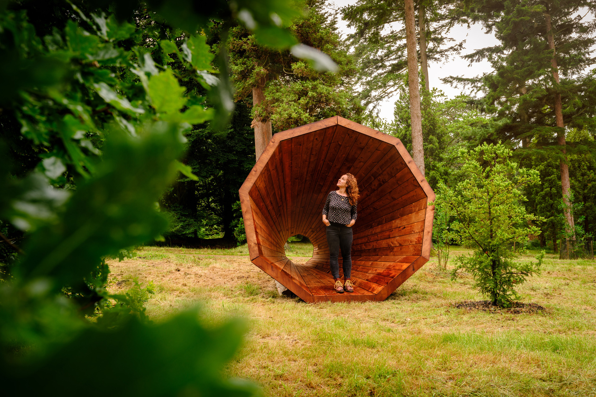 A lady standing in a wooden sculpture