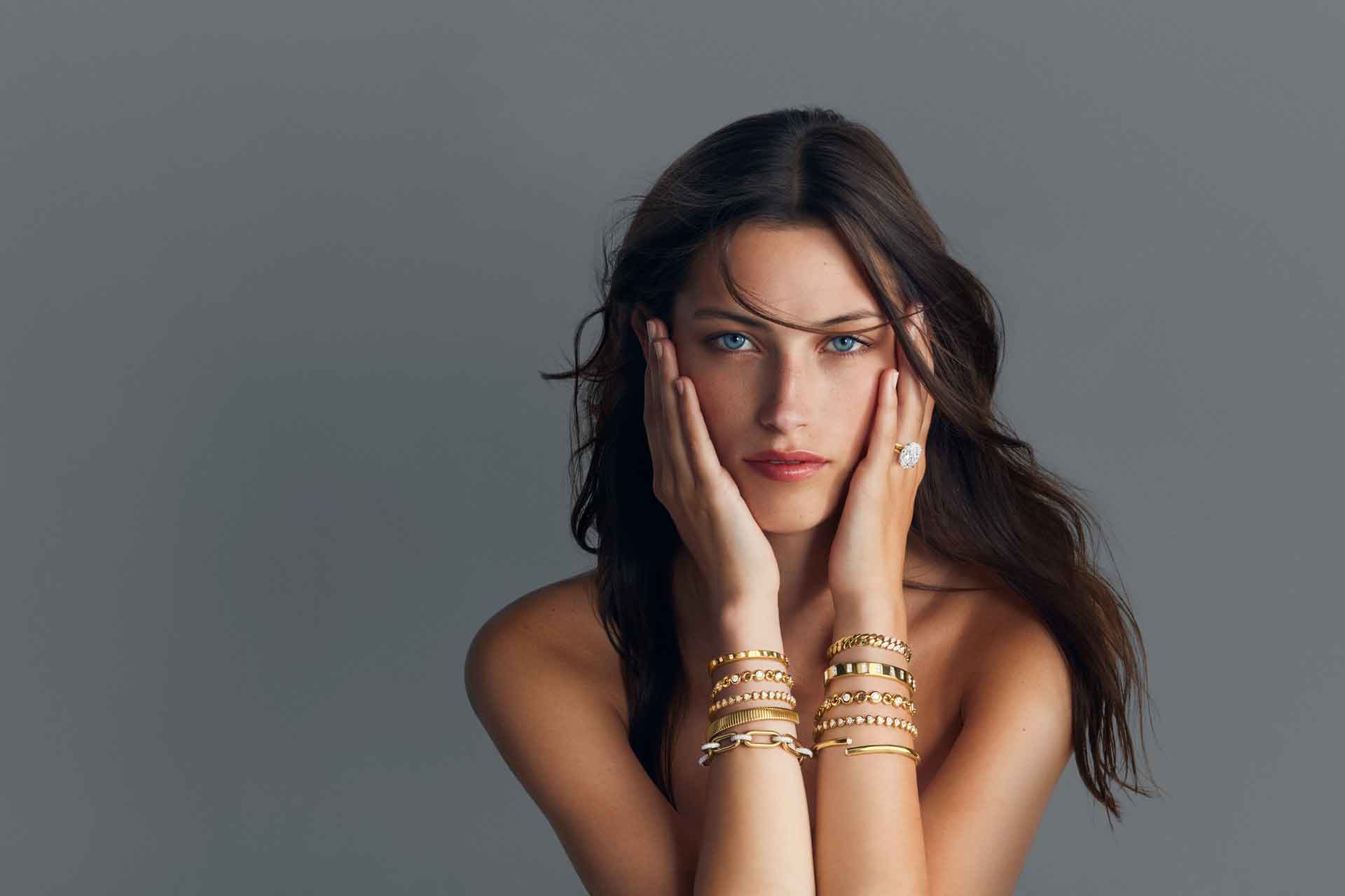 Woman wearing gold bracelet stacks 