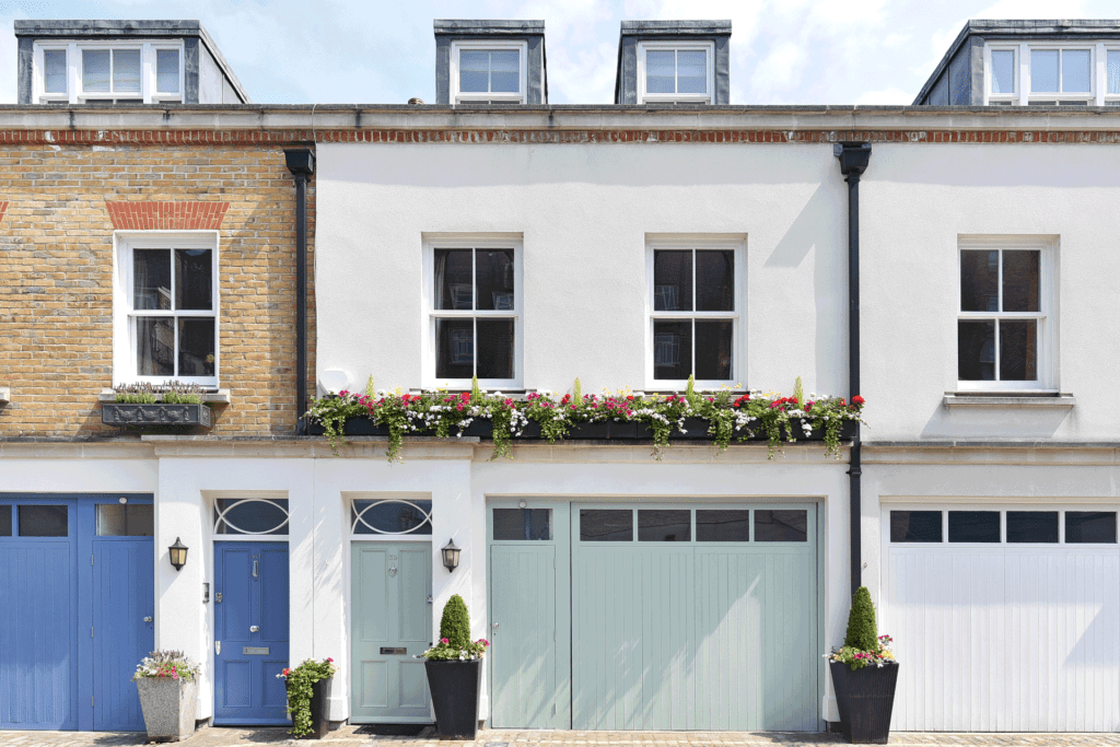 White mews home with seafoam green door and garage door.