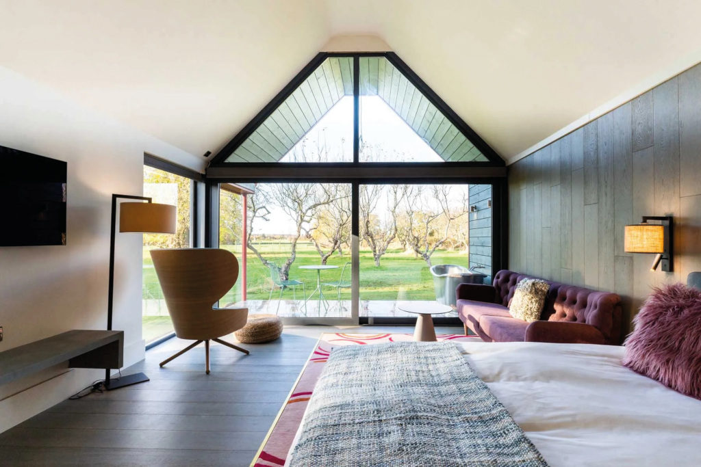Bedroom with open windows onto green