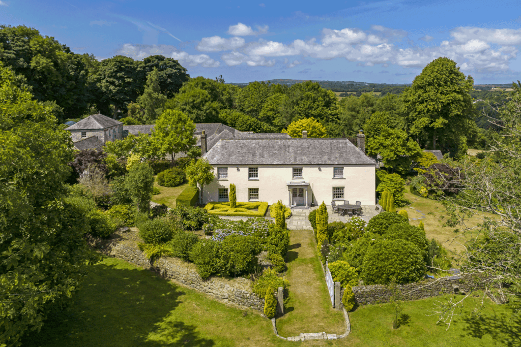 Country home with slate roof sat within lawns.