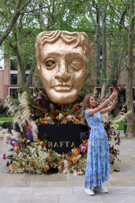 A woman posing with a floral installation in Chelsea