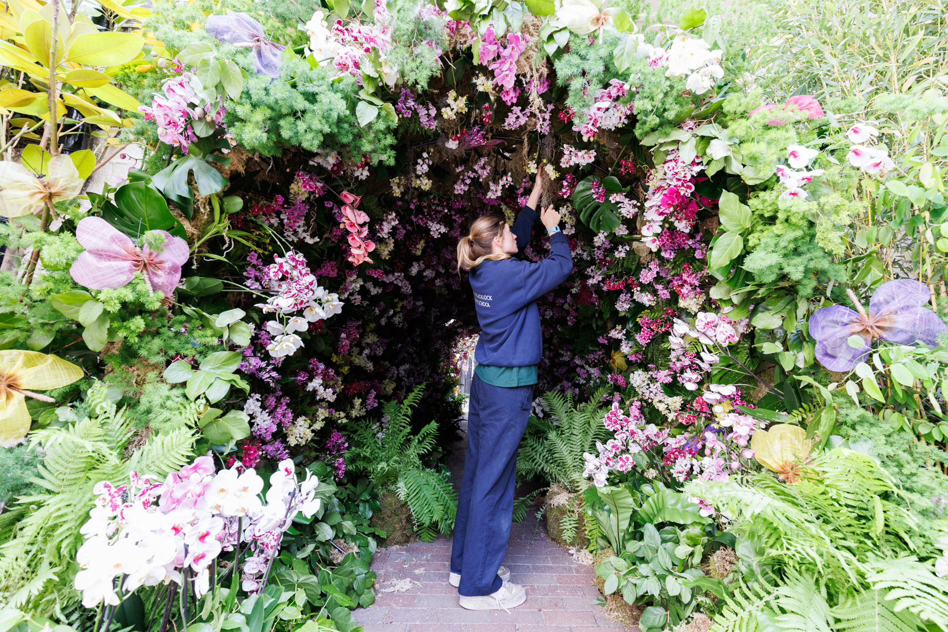 A florist from the Judith Blacklock Flower School puts the finishing touches to a floral installation, ‘Orchids and Butterflies by Judith Blacklock Flower School, in Kinnerton Street, London, which has been designed for the Belgravia in Bloom festival