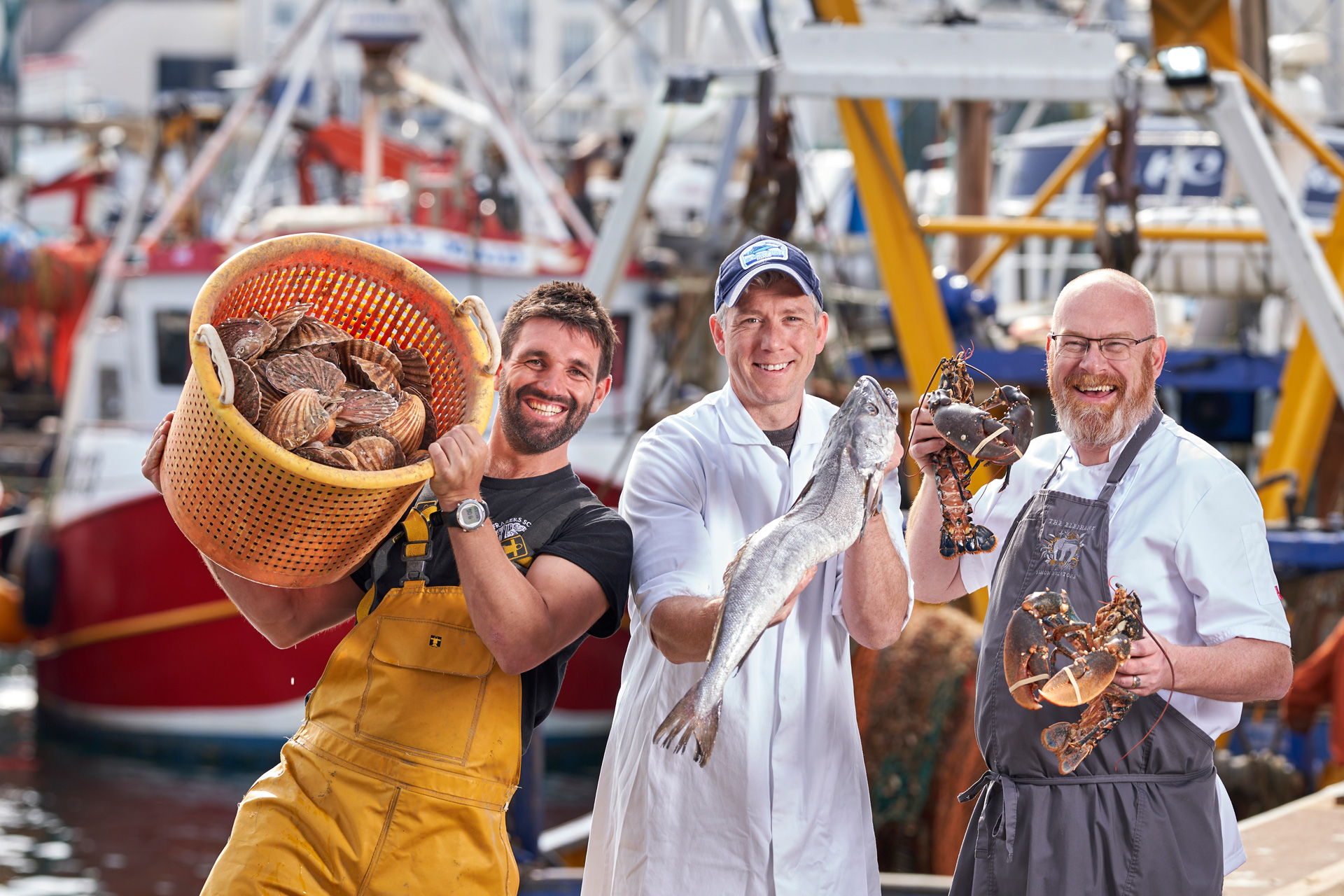 Chefs holding up seafood