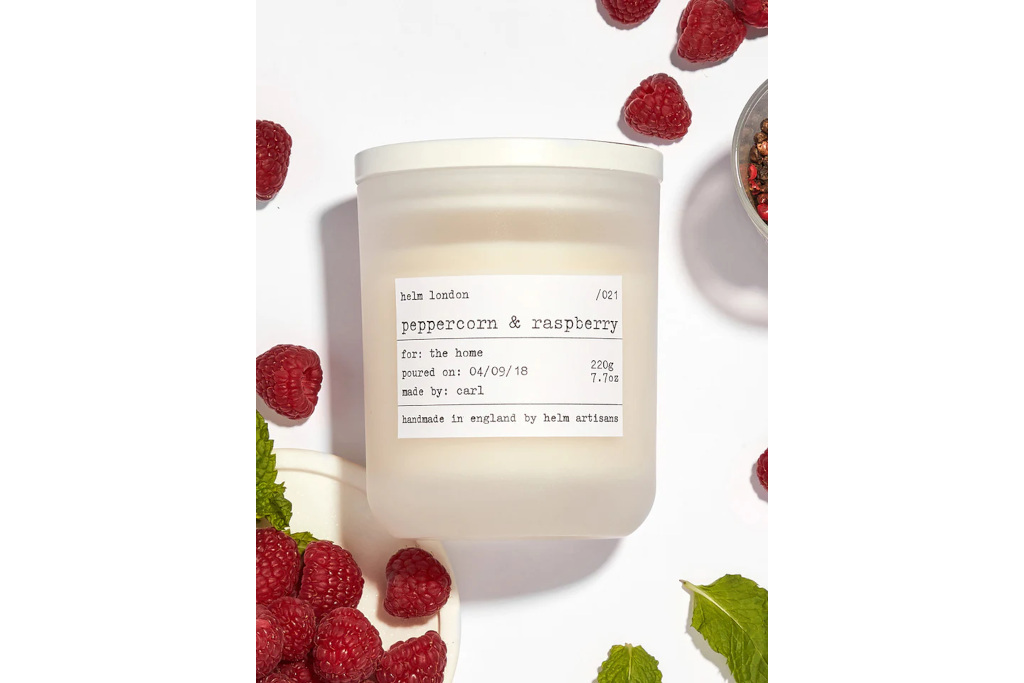 Candle on white background with raspberries