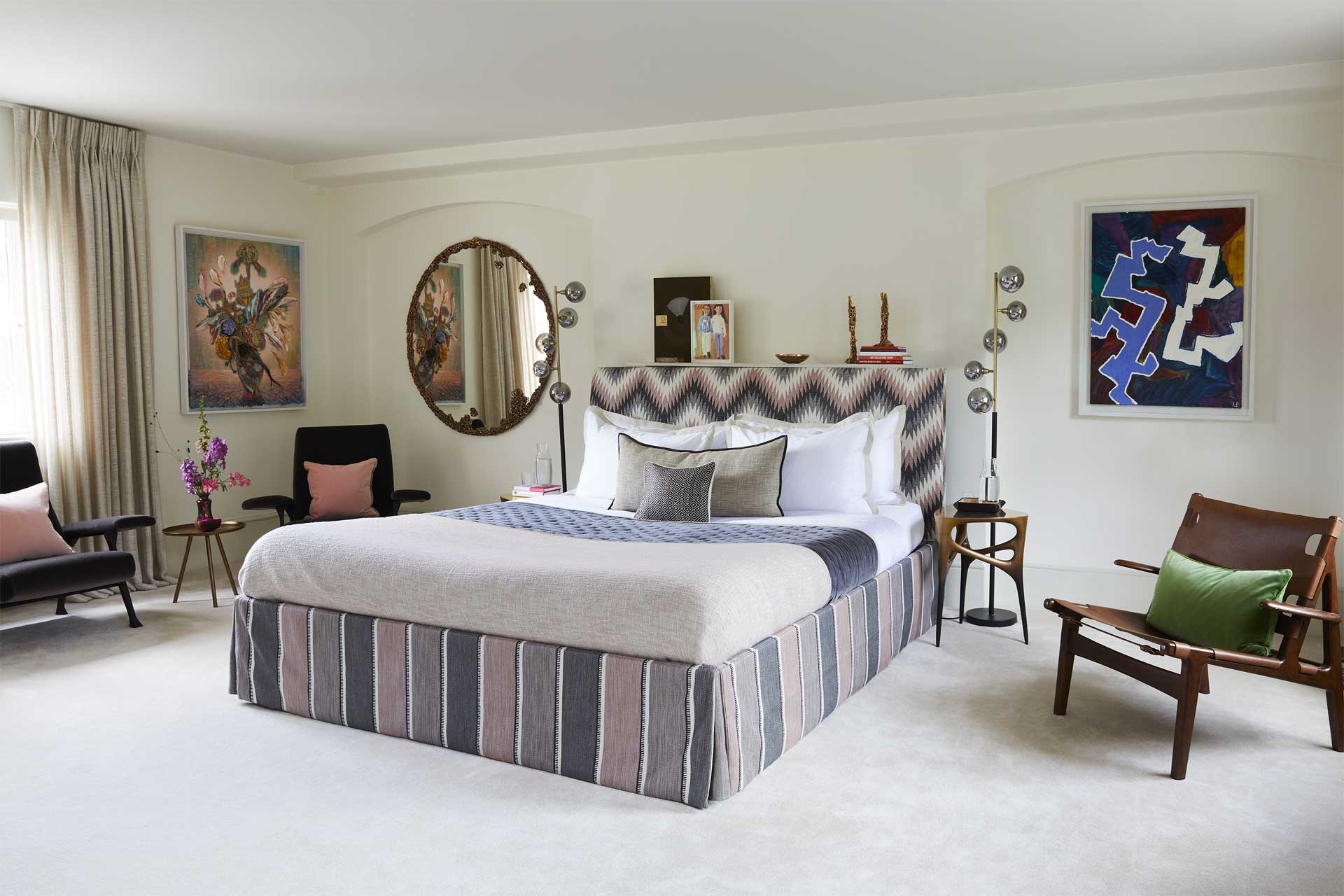 Miriam Frowein's home - a bed sits in middle with a chair to its side and artwork flanking the walls