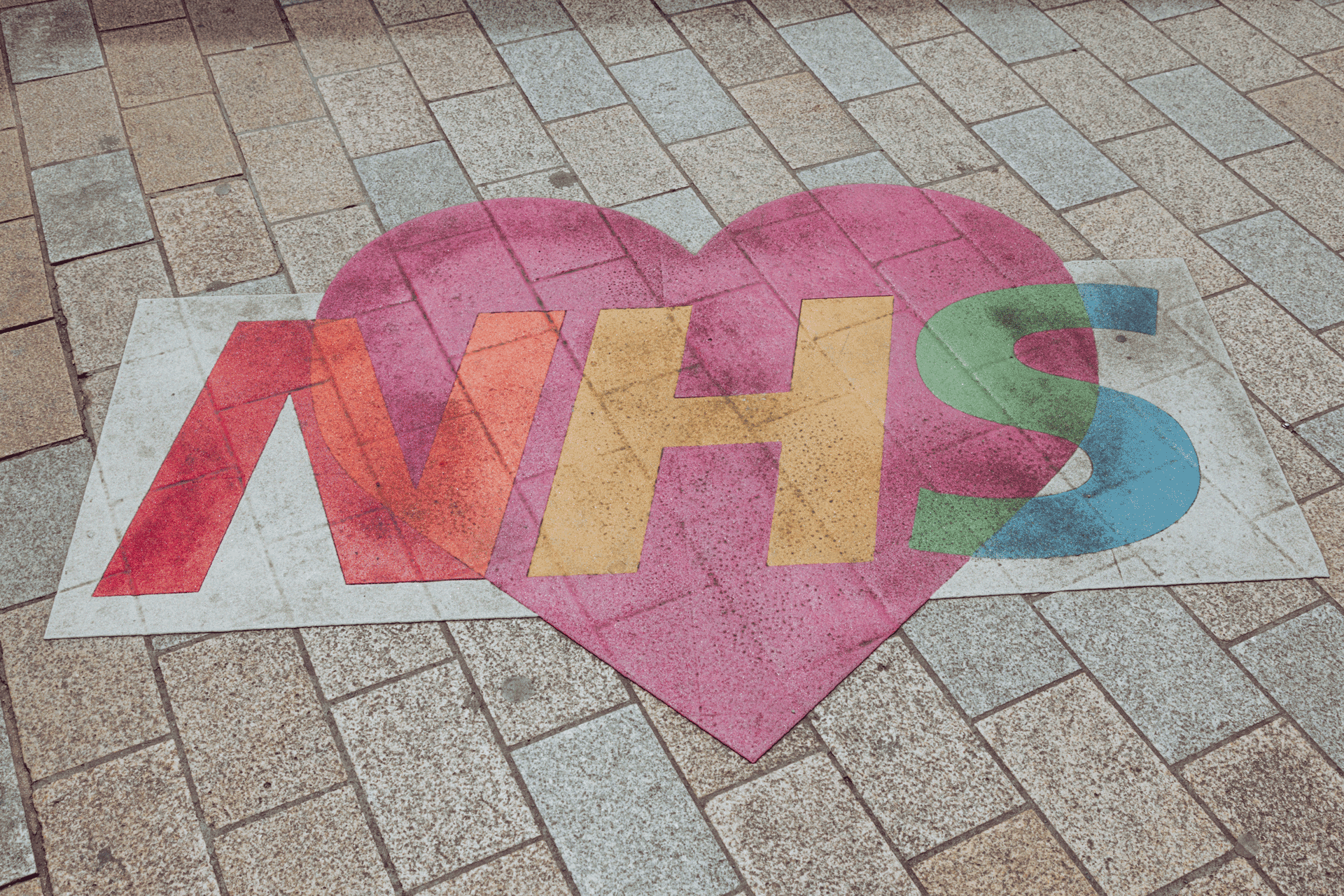 'NHS' written in colourful chalk on the ground.