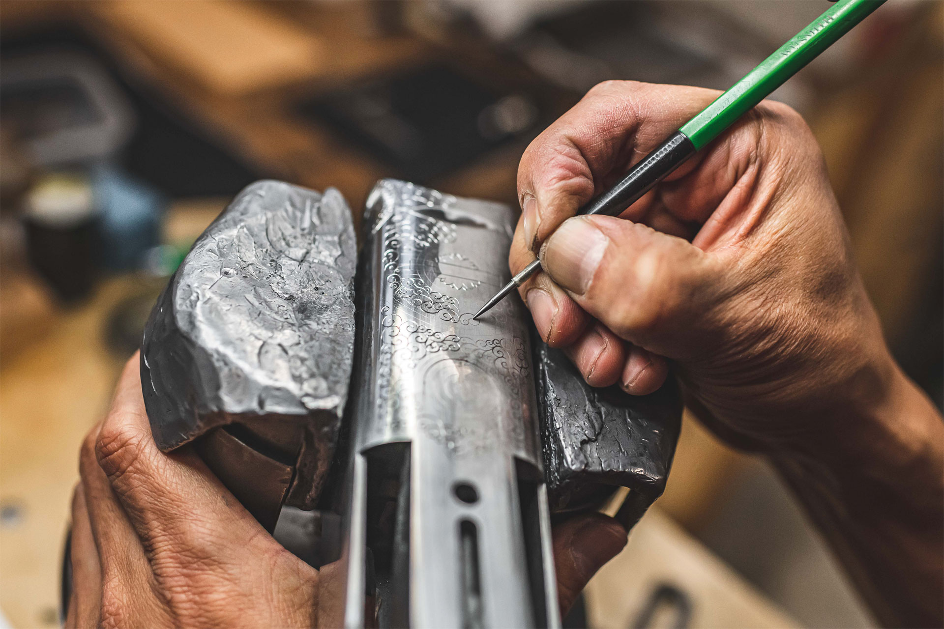 A gunmaker engraves the barrel of a gun