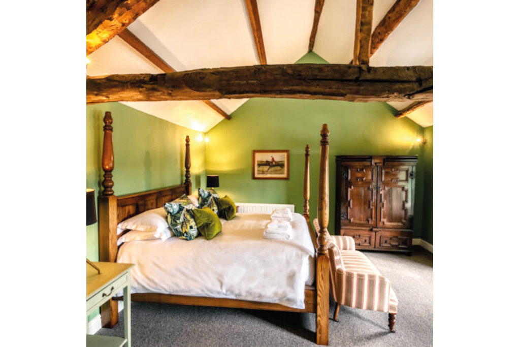 Green bedroom with exposed beam ceilings