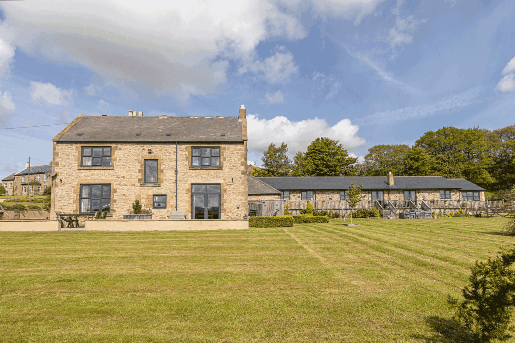 Stone farmhouse with lawns in front.
