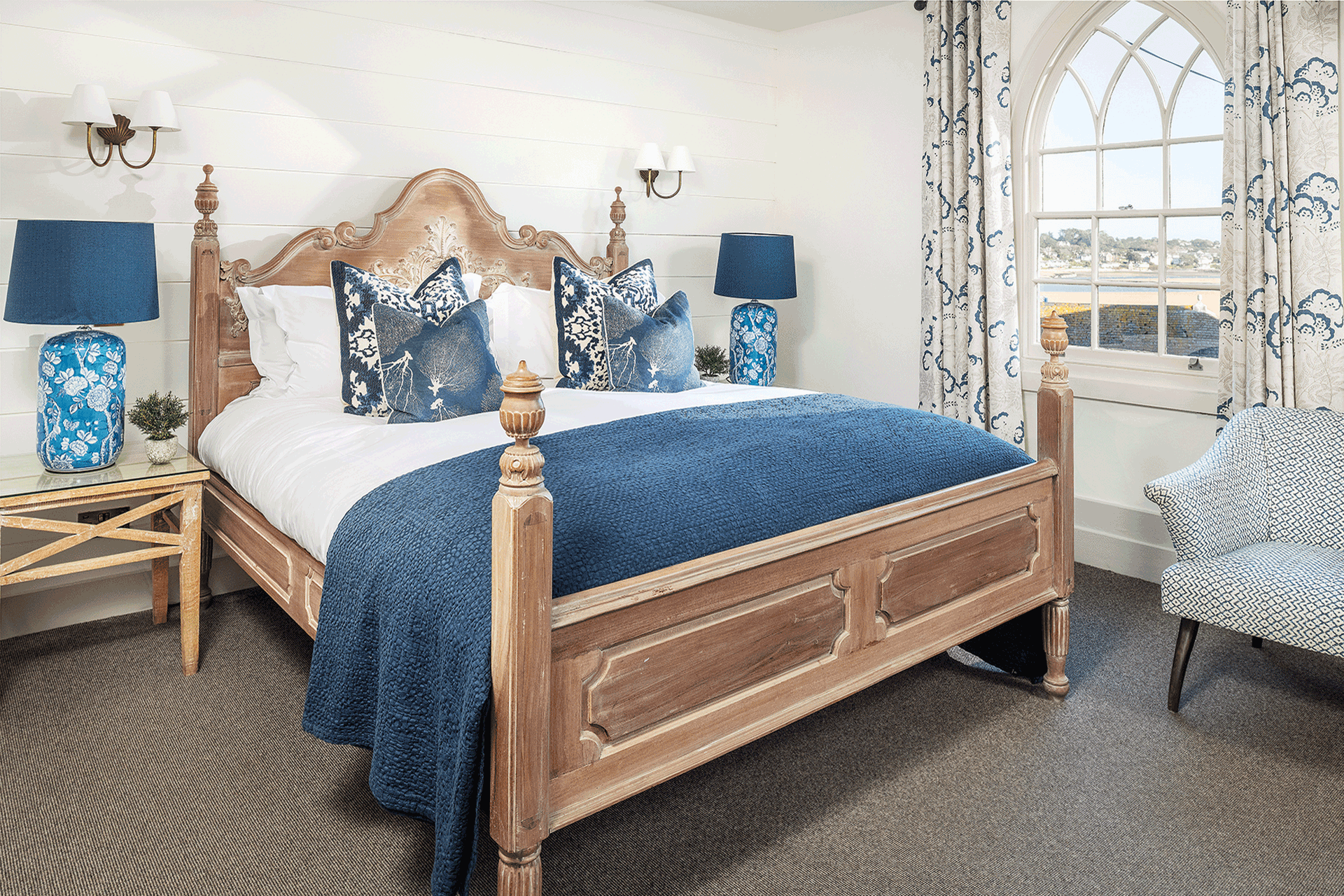 Bedroom with white bedding and blue accents.