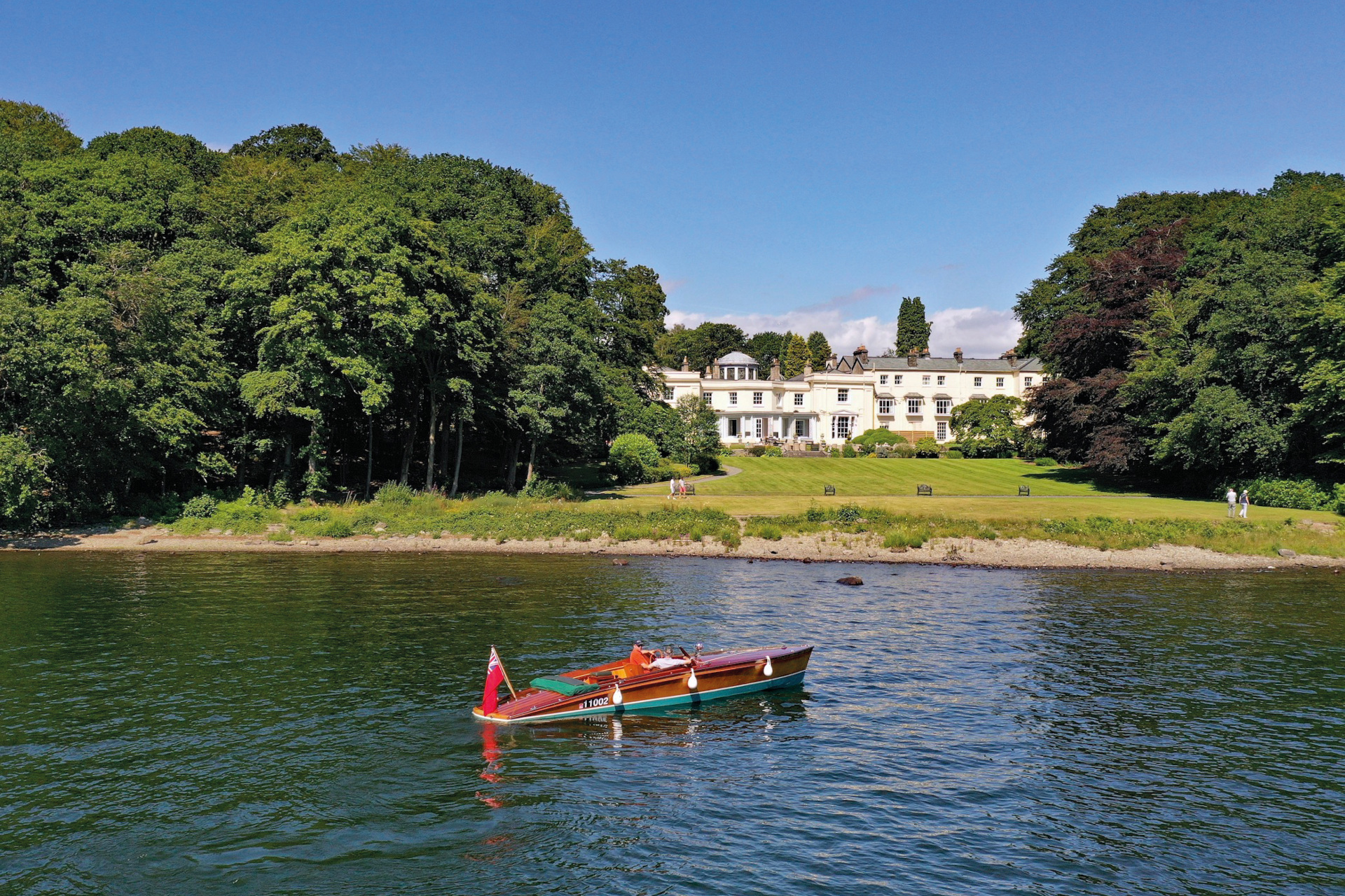 Canoe on lake in front of white hall