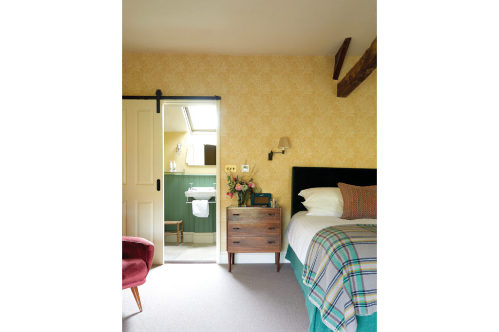 Yellow bedroom with door leading to en suite