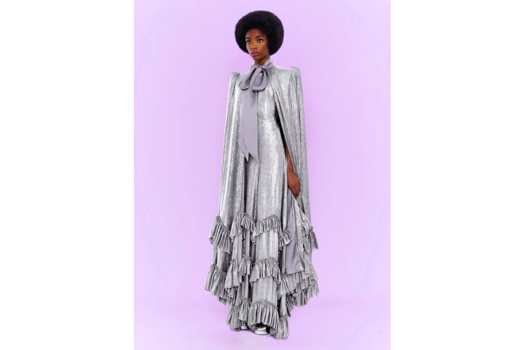 Woman in silver dress and cape on purple background