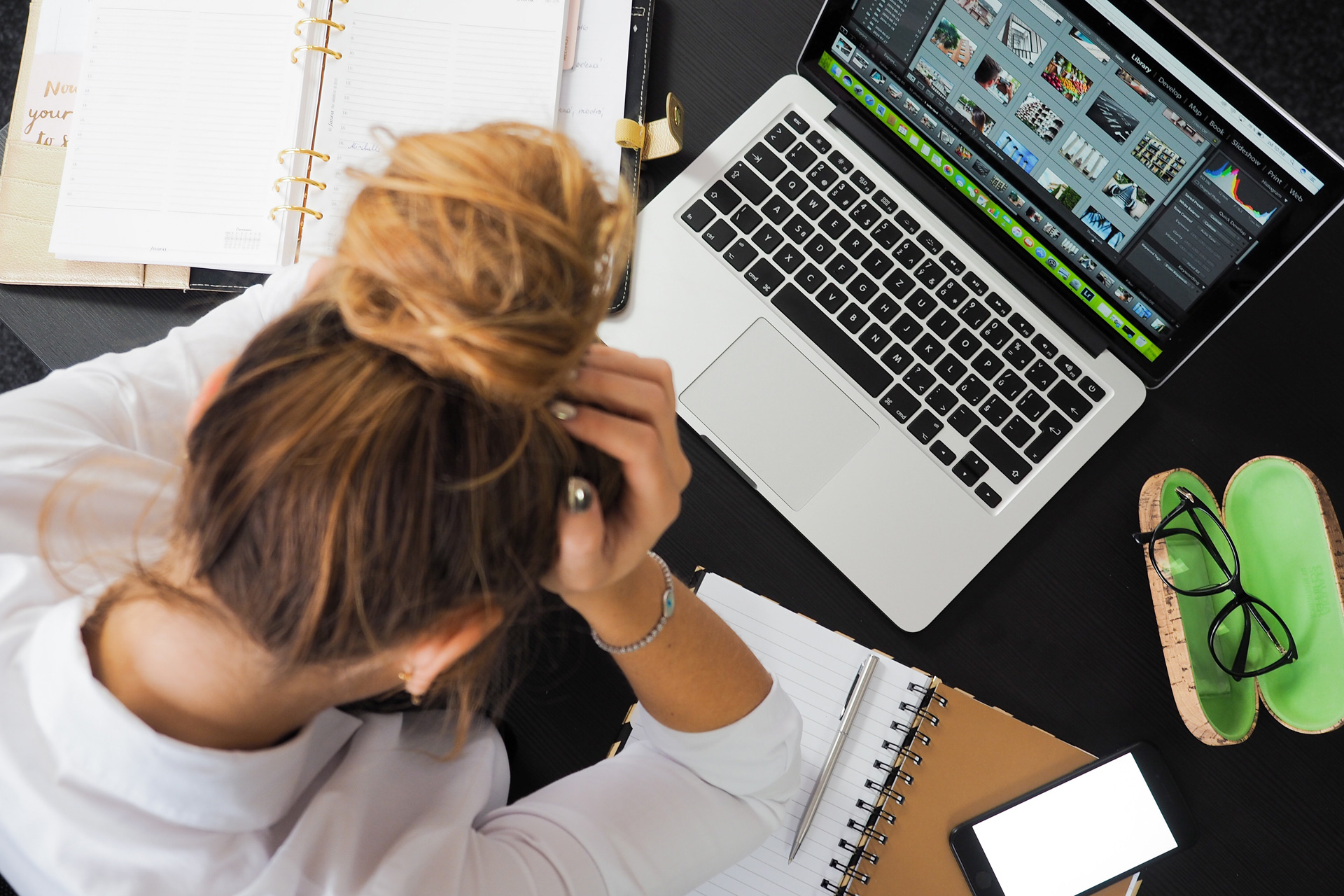 Woman with her head in her hands looking at a laptop