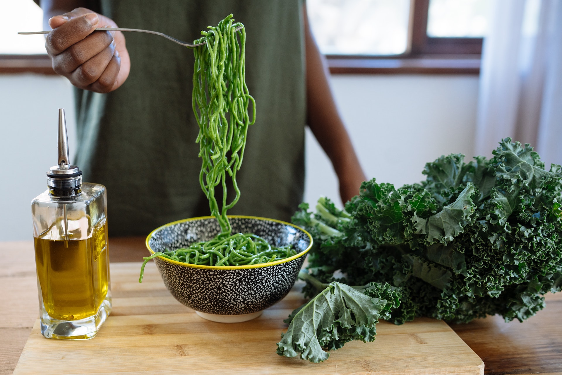 a bowl of spaghetti with olive oil and kale
