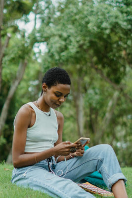 A woman sat outside on her phone