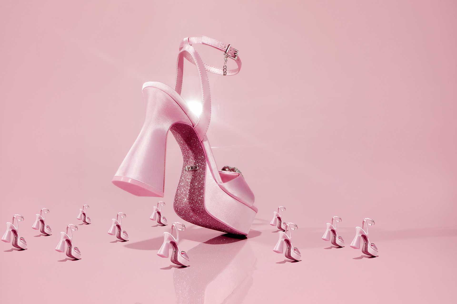 Pink platform heel surrounded by smaller versions on pink background