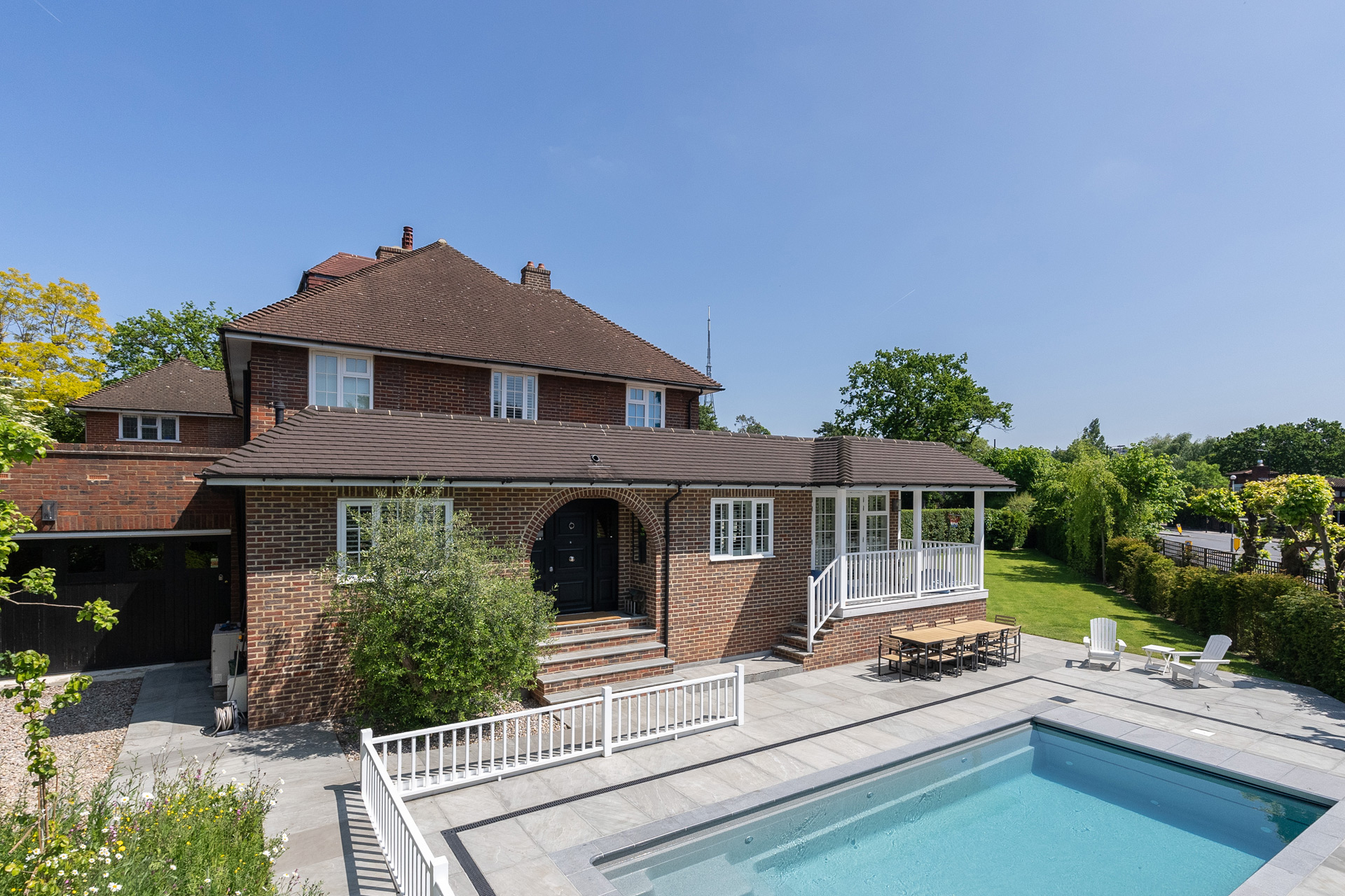 Large detached brick house with outdoor swimming pool.