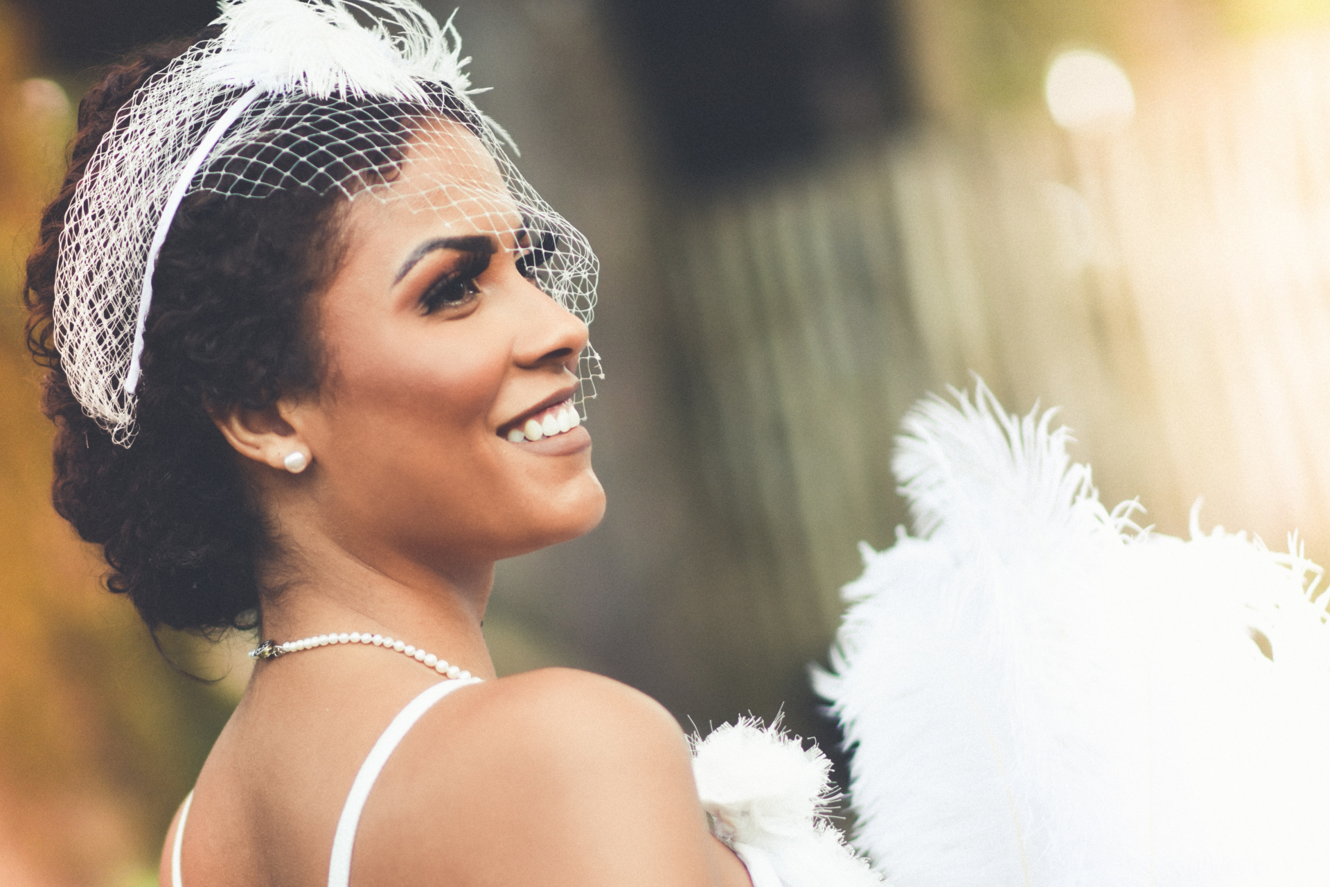 Woman in wedding dress and accessories smiling