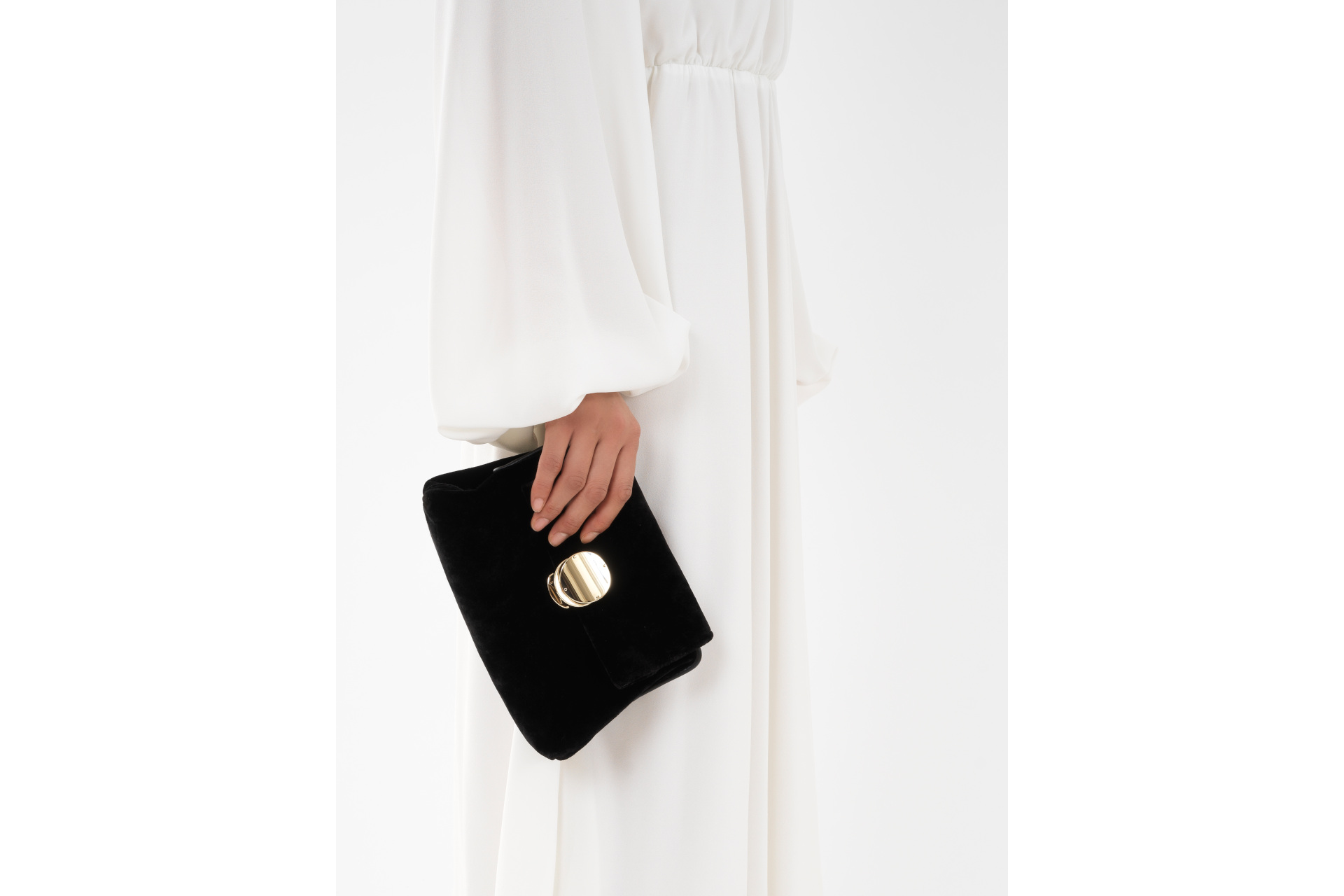 Woman in white dress with black clutch bag