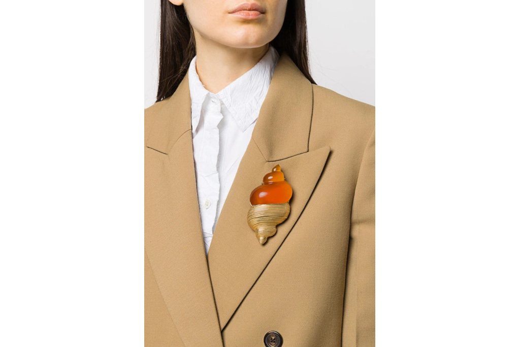 Woman wearing shell brooch on blazer