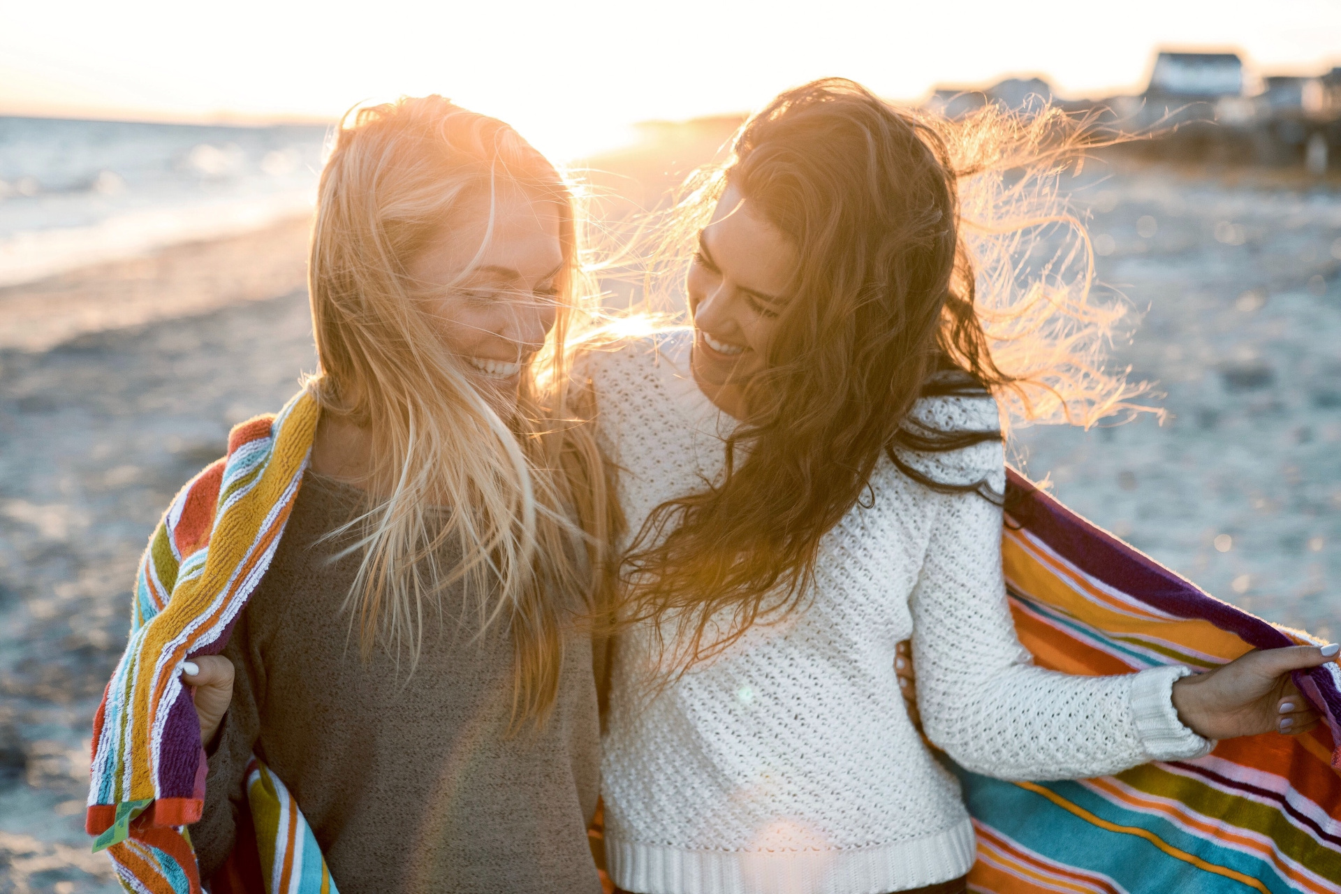 Two women on the beach together at sunset