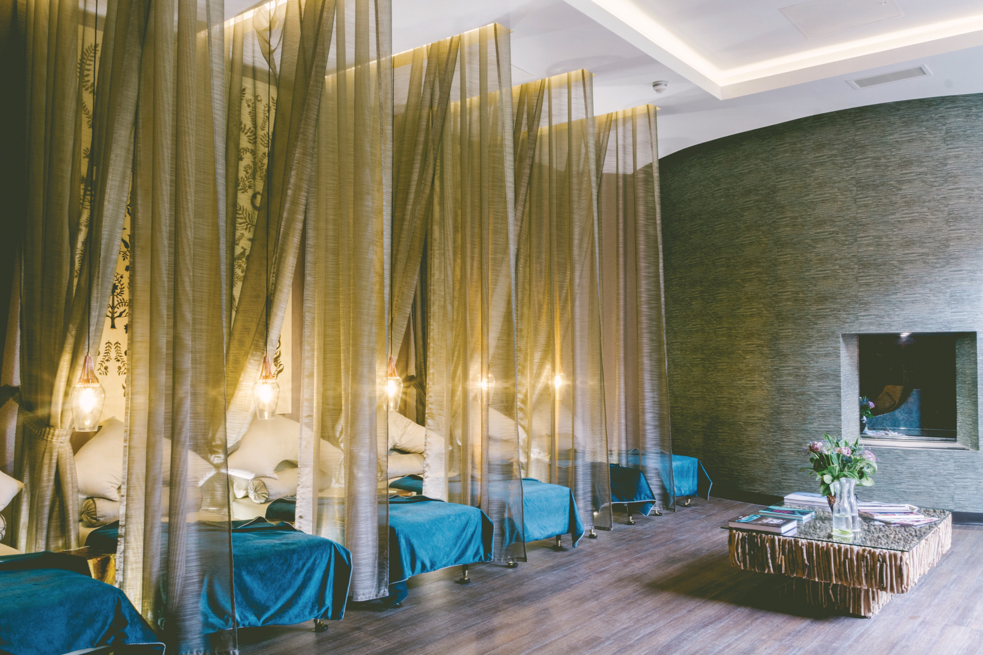 Spa relaxation room with gauze curtains and blue beds
