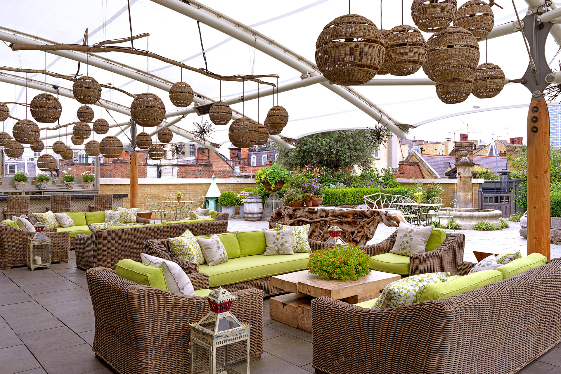 Ham Yard Hotel roof terrace, with lime green cushions and hanging 'beehive' decorations.